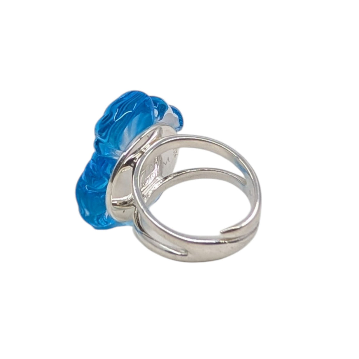 A silver-toned ring featuring a large, sculptural blue glass ring on a plain white background.