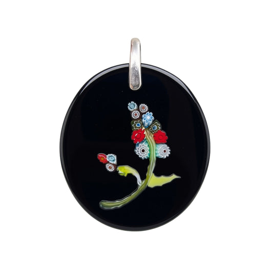 An oval black glass pendant featuring a delicate floral design with red, blue, green, and white details, suspended from a silver bail on a white background.