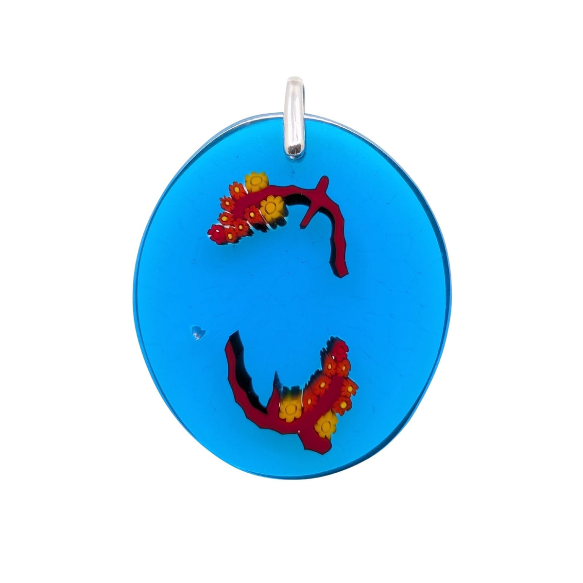 A round blue pendant featuring two red and yellow coral-like designs, suspended from a silver bail, shown against a plain white background.