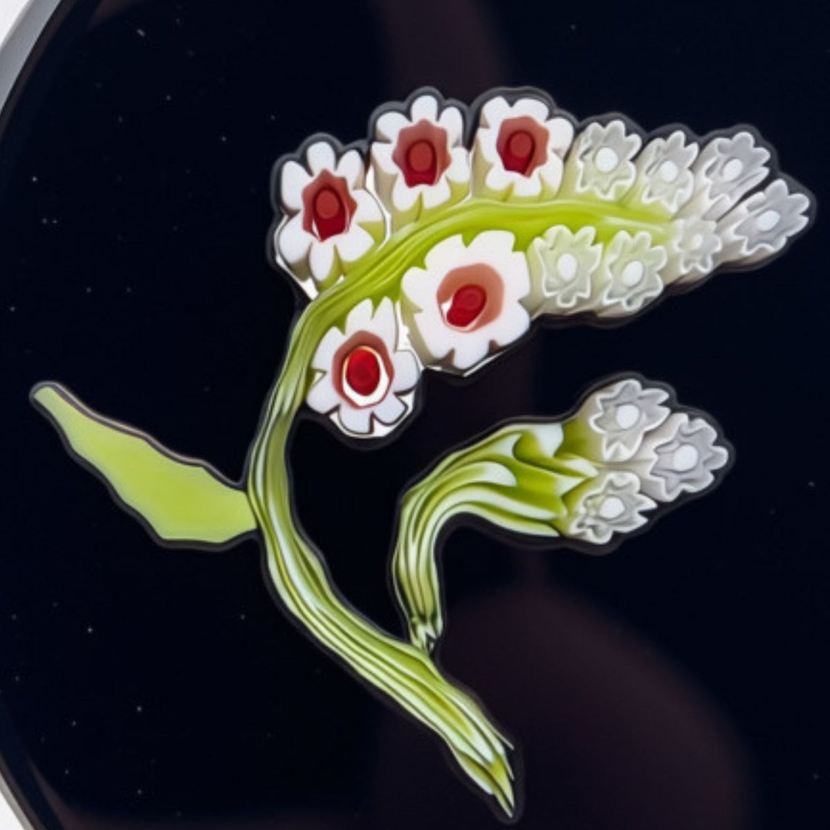 A close-up of a decorative floral design featuring white blossoms with red centers and light green stems on a dark background.