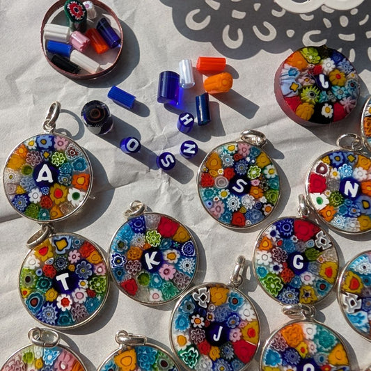 group of millefiori murano glass pendants with letters within.