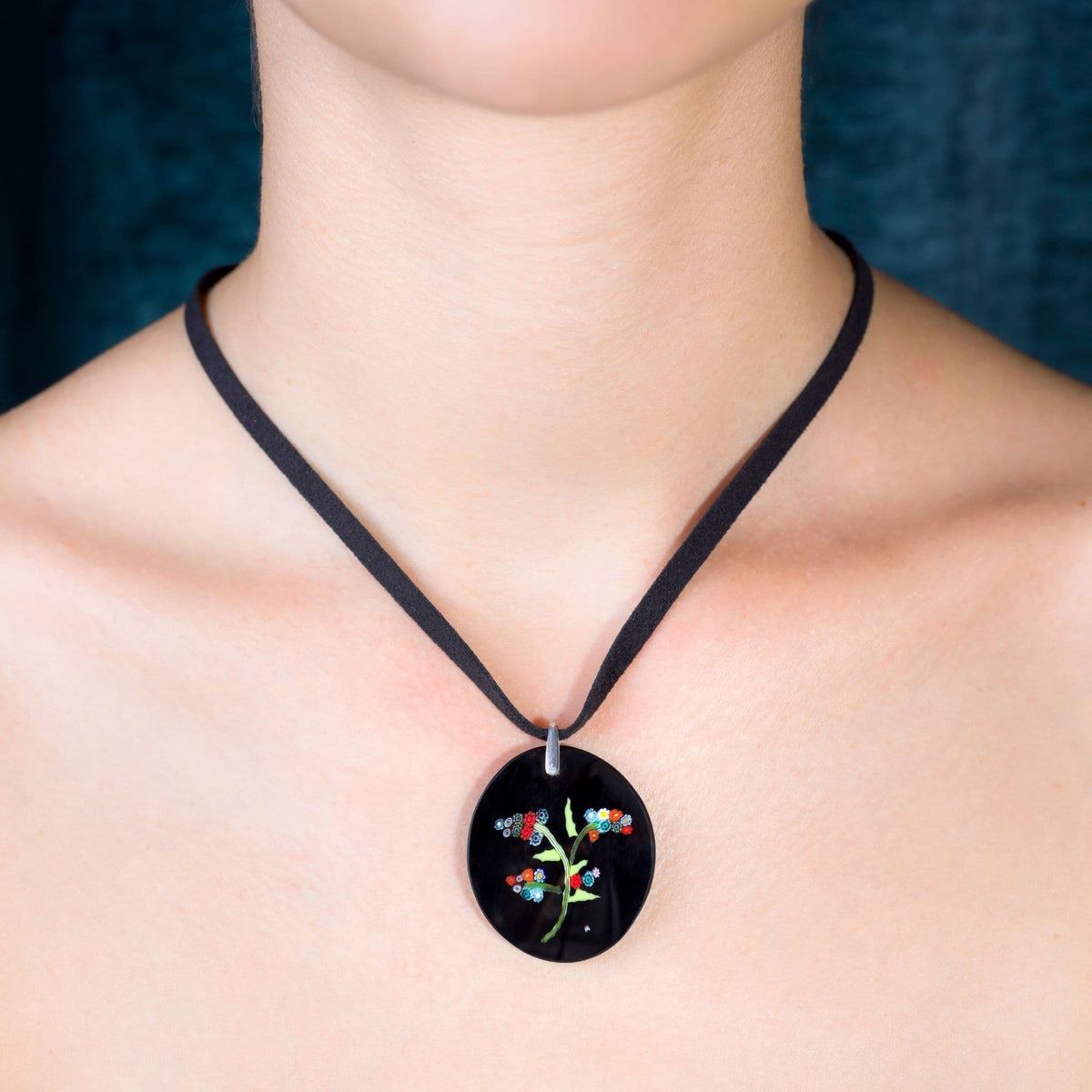 a neck wearing a multicoloured millefiori glass pendant.