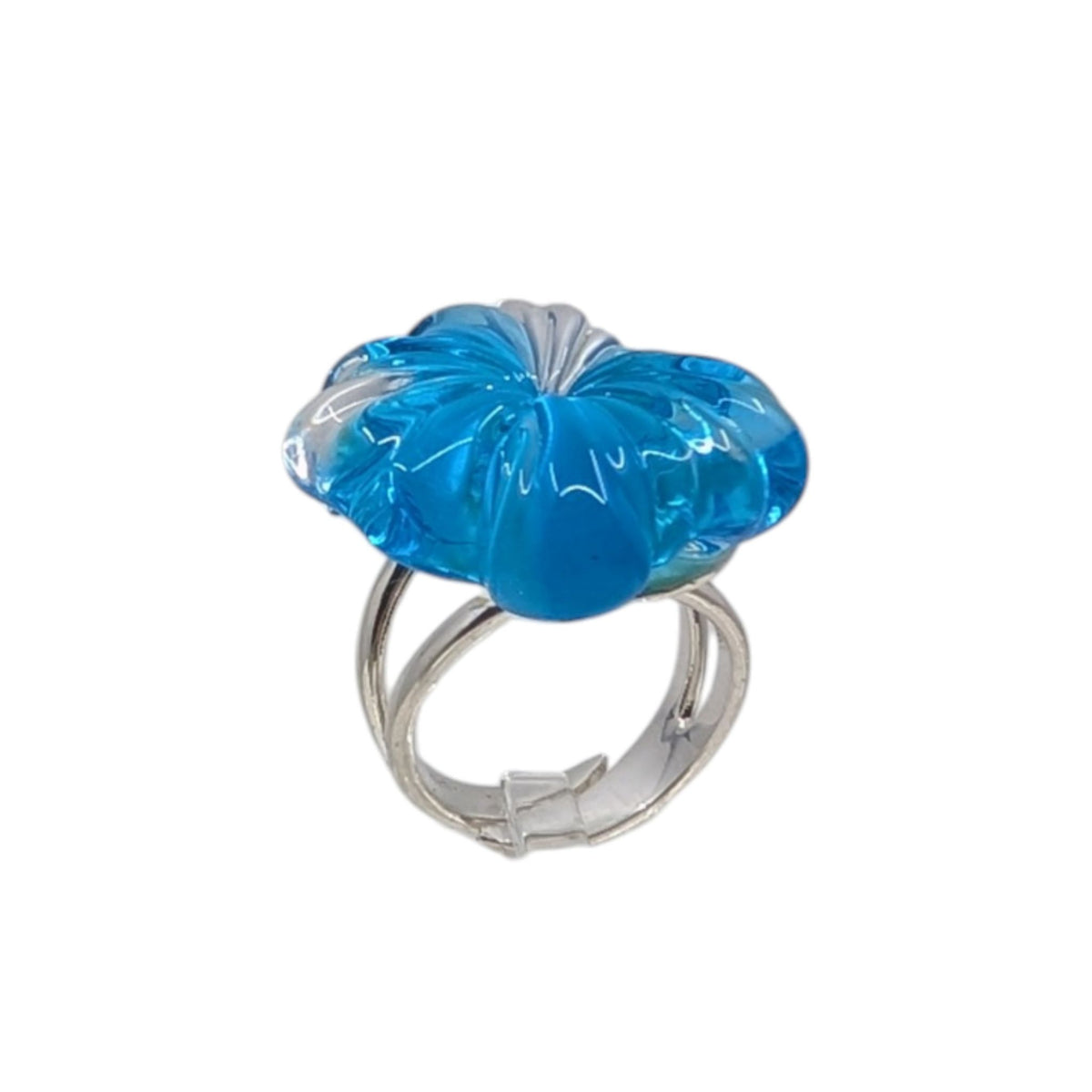 A silver ring featuring a large, sculptural flower-shaped cabochon in vibrant blue glass, set against a plain white background.